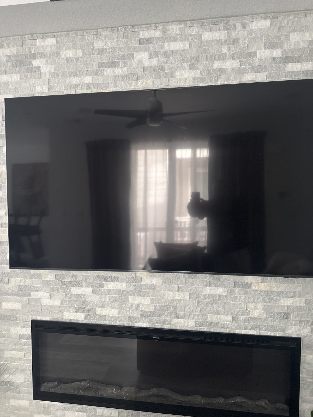 TV mounted on stone over a fireplace by AI Low Voltage